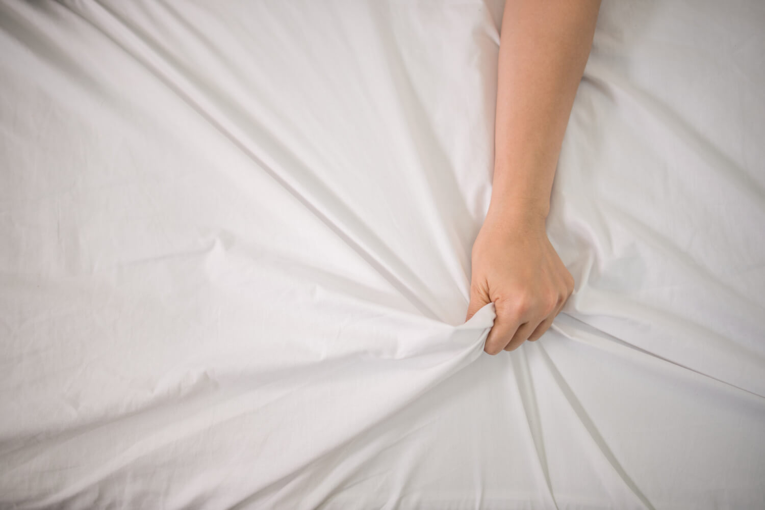 Mulher apertando lençol de cama